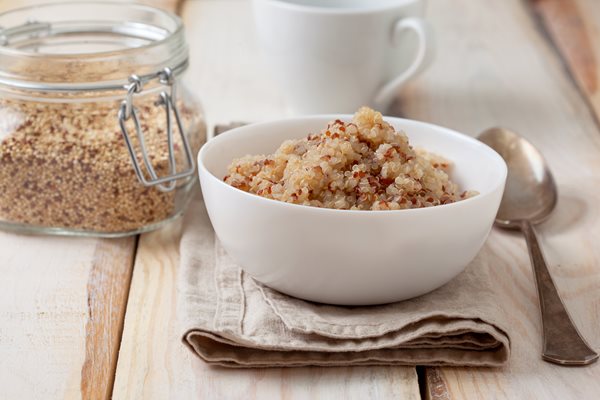 Dietary-healthy-breakfast-Cooked-quinoa-in-a-white-bowl-cup-of-tea-on-a-wooden-background_shutterstock_533614714.jpg